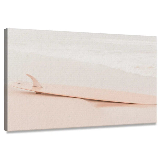 Blush surfboard resting on beach sand—canvas wall art for bedroom decor, soft pastel tones evoke peaceful coastal atmosphere