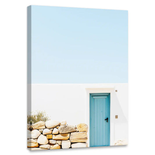 Minimalist Mediterranean canvas wall art for bedroom featuring blue door and stone wall under pastel sky