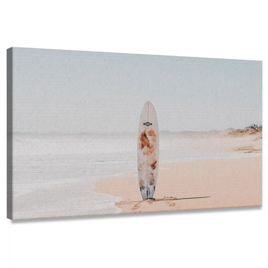Surfboard on beach — large canvas wall art with pale sand and soft blue tones, peaceful coastal décor for modern living room design