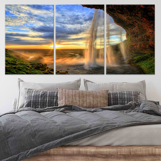 Iceland sunset waterfall framed by cave rocks — large canvas wall art ideal for bedroom decor, creating a calming and dramatic natural atmosphere.