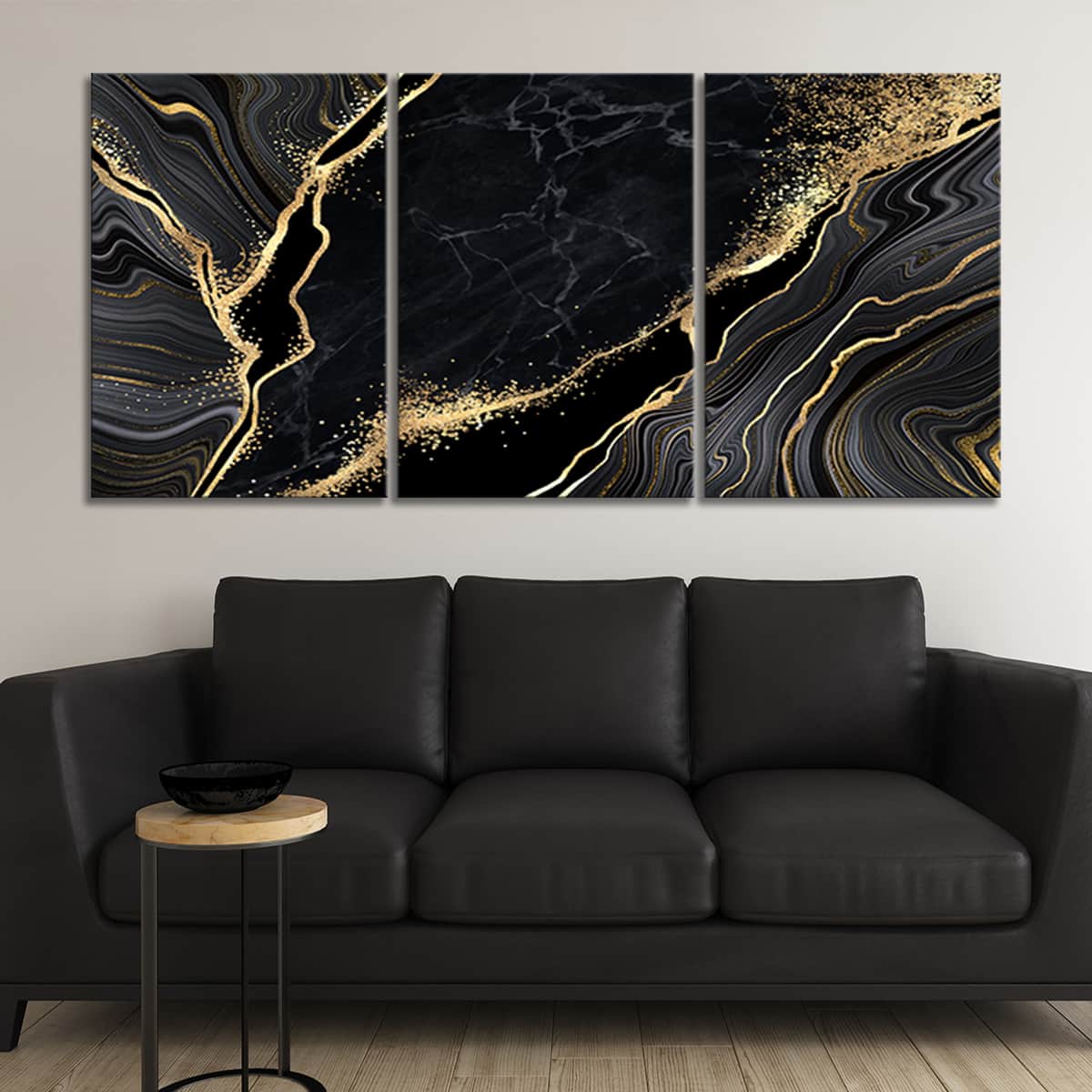 Black wall art of abstract marble with gold accents on a large canvas above a contemporary grey couch with white throw pillows.