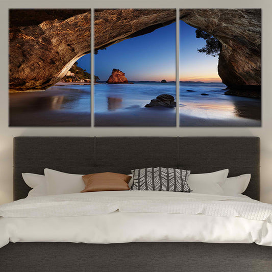 Golden sunset reflection — coastal canvas print with cave arch and blue ocean hues, peaceful artwork for tranquil bedroom atmosphere