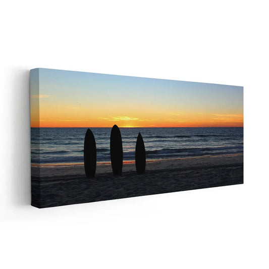 Surfboard silhouettes at sunset — coastal canvas print for living room decor, evoking warmth and seaside adventure