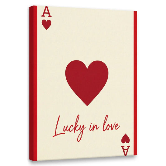 Minimalist canvas wall art featuring a bold red heart, stylized playing card elements, and the phrase 'Lucky in love' in red text.