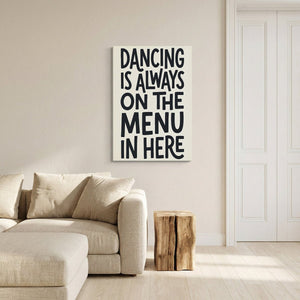 Minimalist canvas print with centered stacked text that reads 'DANCING IS ALWAYS ON THE MENU IN HERE' in bold lettering.