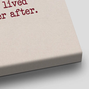 Whimsical canvas wall decor with a simple black line drawing of a couple and red heart symbols, set against a beige background.