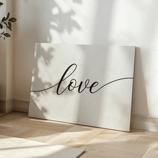 Minimalist canvas wall art with centered cursive 'love' text in black on a white backdrop, suited for romantic spaces.