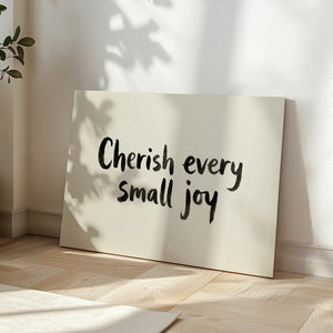 Canvas wall art with a monochrome palette and clean brush-like text spelling 'Cherish every small joy'