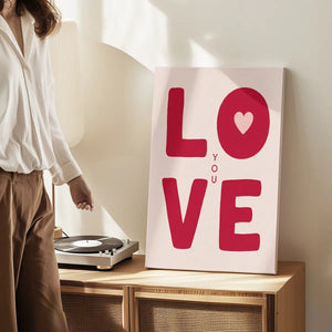 Canvas wall art print with affectionate red lettering and graphic heart detail, designed for casual romantic-themed interiors