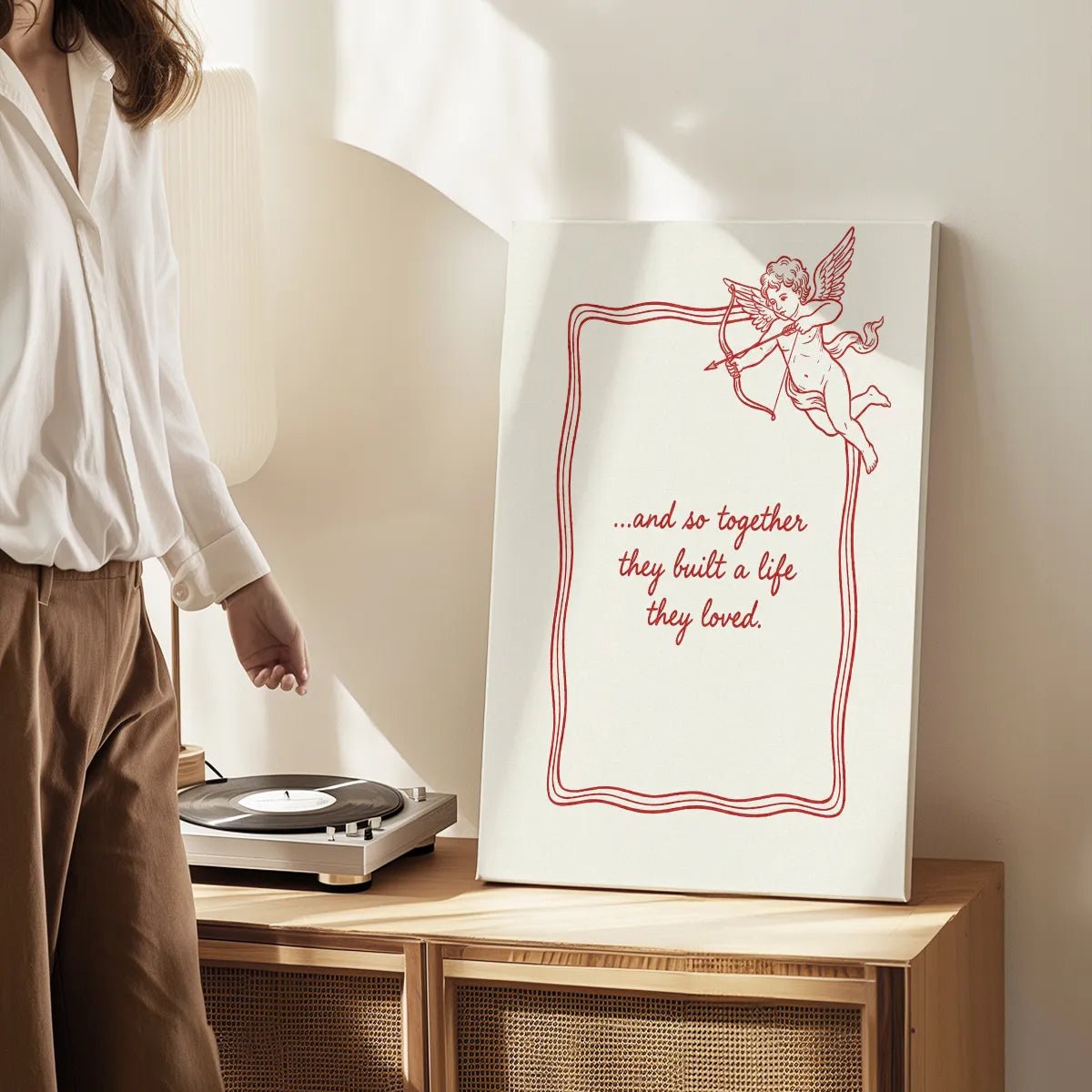 Canvas wall art print with clean line art of cupid and heartfelt cursive text, styled for romantic-themed interior decor.