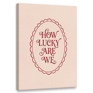 Minimalist canvas wall art featuring red text 'HOW LUCKY ARE WE' centered inside a scalloped oval on a beige background
