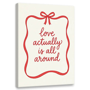 Minimalist canvas wall art featuring red cursive text 'love actually is all around' framed by a red ribbon and bow on white background