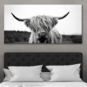 Large Highland cow canvas wall art over bed in neutral farmhouse bedroom interior