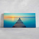 Ocean canvas print with a wooden pier leading to a glowing sunset.