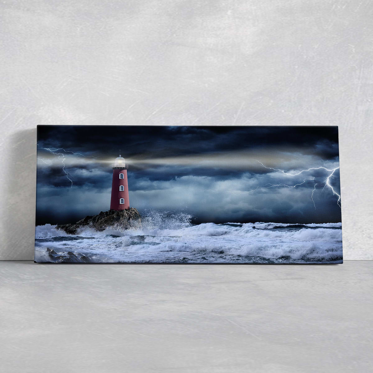 Stormy sea wall art with a lighthouse standing against crashing waves.