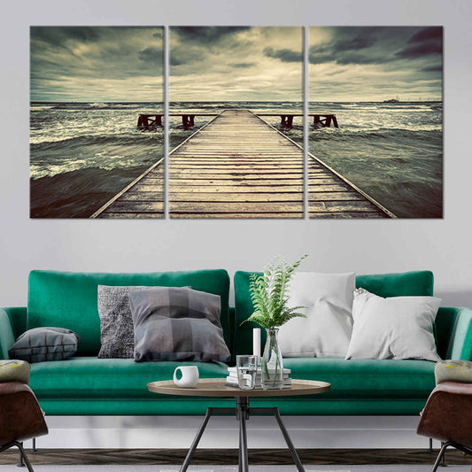 Beach scene canvas art featuring a weathered wooden pier extending into rough waters.
