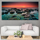 Serene beach rocks at dusk with golden-red sky in a large wall art decor piece.
