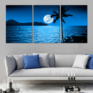 Tropical canvas wall art depicting a silhouetted palm tree against moonlit waters.
