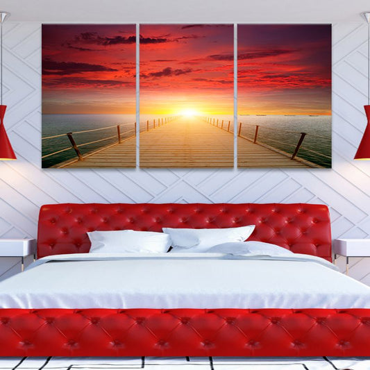 Coastal wall art for bedroom with a vibrant sunset over calm ocean waters.